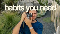 Photographer holding vintage film camera with succulents and desert plants in background