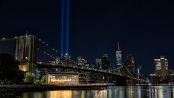 Brooklyn Bridge and Manhattan skyline at night with Tribute in Light beams