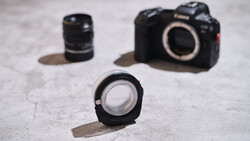 Canon R5 mirrorless camera body and three Canon RF lenses arranged on concrete surface
