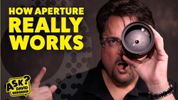 Man holding spherical lens demonstrating aperture principles with yellow text overlay