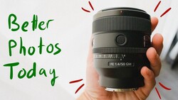 Hand holding a Sony FE 1.4/50 GM prime lens against a white background