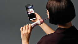 Person holding a foldable smartphone displaying a photo application on its screen