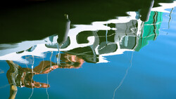 Aerial view of a landscape reflected in still water, creating a mirrored composition