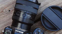 Tamron lens with lens cap and camera body on wooden surface