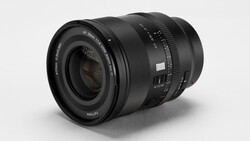 Black 35mm f/1.4 autofocus camera lens angled on a light gray studio backdrop, showing its front element and barrel markings