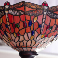 Tiffany-style stained glass lamp shade with red dragonfly motif and amber glass accents