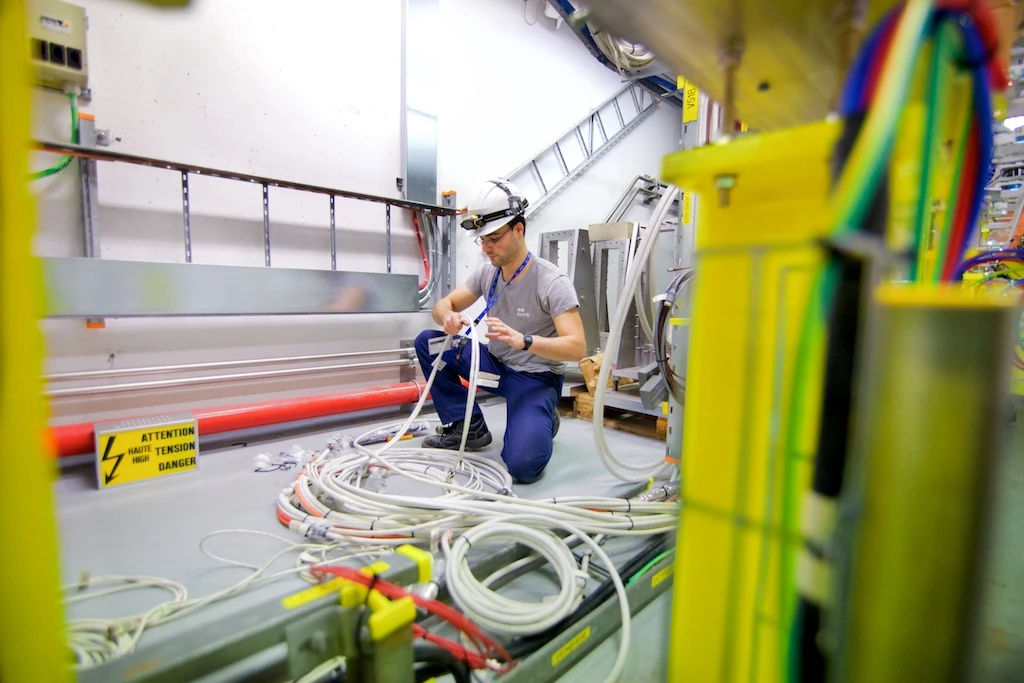 An engineer works on cabling at the LINAC4 - Photo by Ruben Lammerink