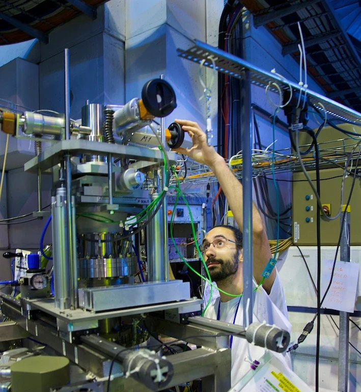 A scientist calibrates an experiment at ISOLDE - Photo by Ruben Lammerink