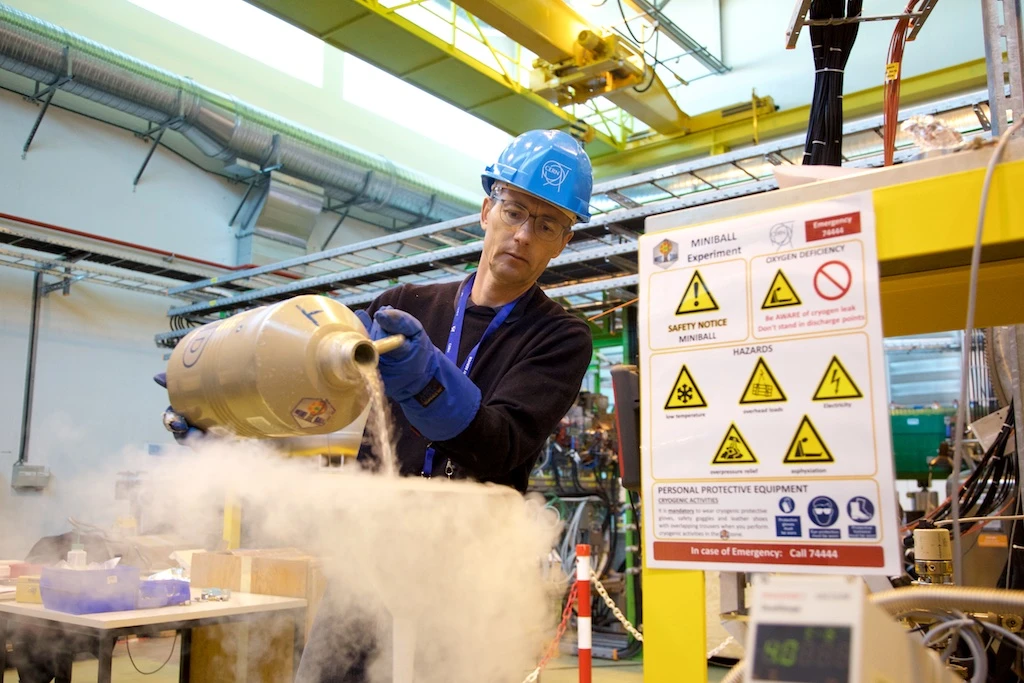 An engineer pours liquid nitrogen to cool a component in ISOLDE - Photo by Ruben Lammerink