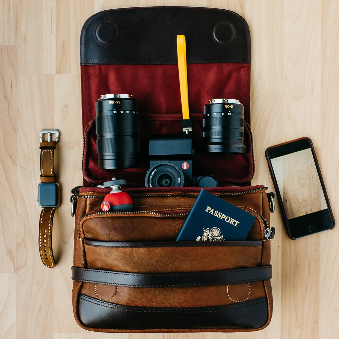 Photo of Leica T Mirrorless Camera with travel essentials in a Wotancraft Ryker bag