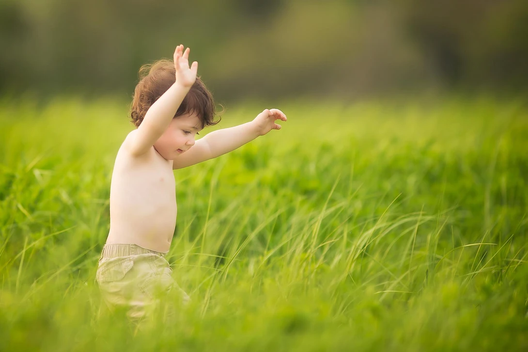 boy running in tall grass