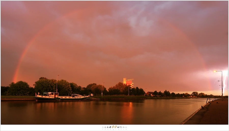 A red sky during sunset, with a rainbow that is almost completely red. This is called a redbow. A keen eye will spot also lightning at the right side of this shot. (Canon EOS 5D3 with 17mm | ISO200 | f/13 | 4 sec) 
