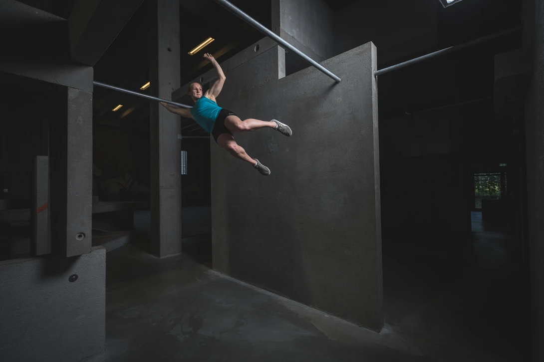 Andy Day BGI parkour photoshoot - Emilie swinging between bars