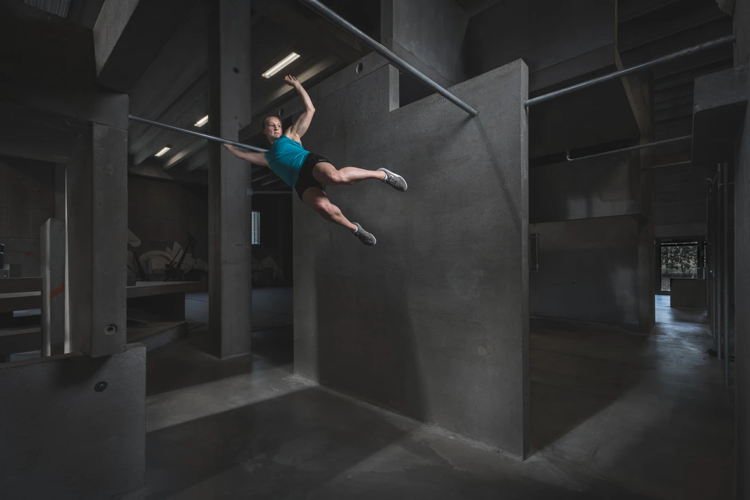 Andy Day BGI parkour photoshoot - Emilie swinging between bars