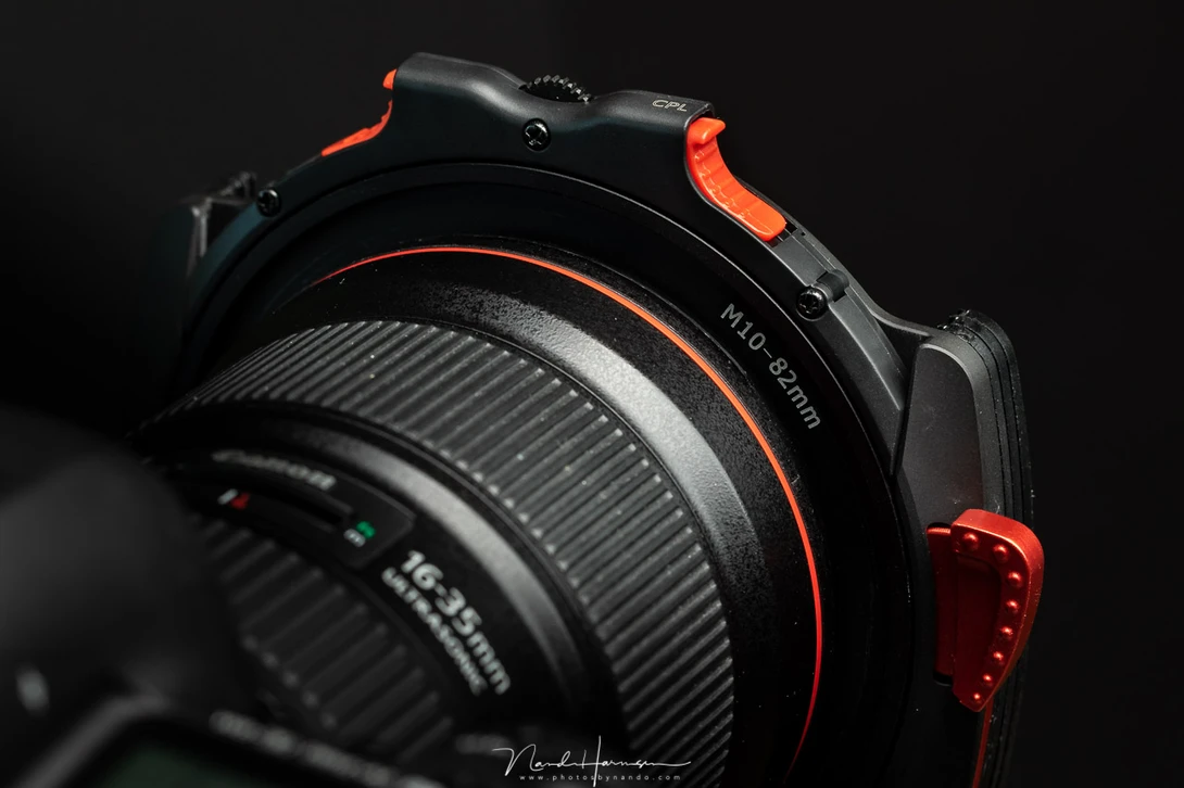 The filter holder is hold in place by a spring-loaded red lever. There is no risk of losing the filter holder with normal use. And by change it fits quite nicely with the red L-series lenses. I am sure it will also fit with the red accent of the Nikon cam