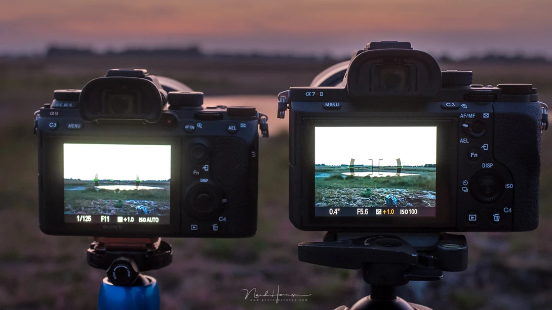Two modern Sony cameras next to each other. The LCD screen already shows the result of the manual settings. But it also mentions it is 1 stop overexposed, which is based on the measurement of the light meter.