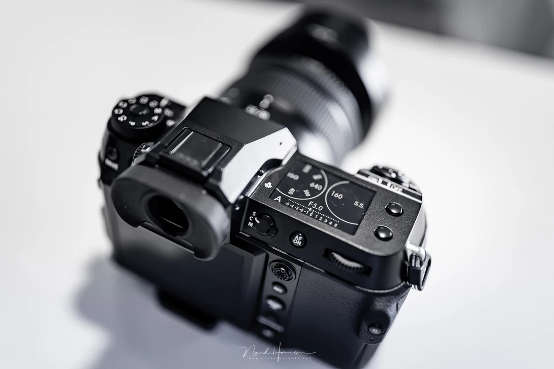 Professional mirrorless camera with attached lens mounted on white surface.