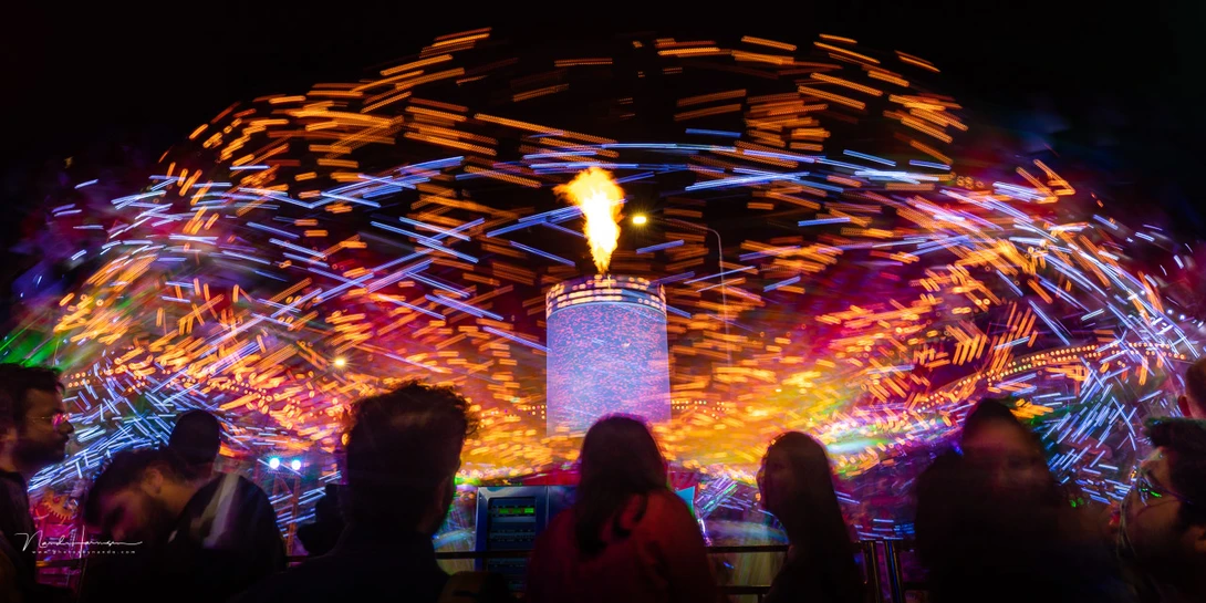 Capture the silhouettes of people in front of an attraction. It doesn't matter if they're moving.