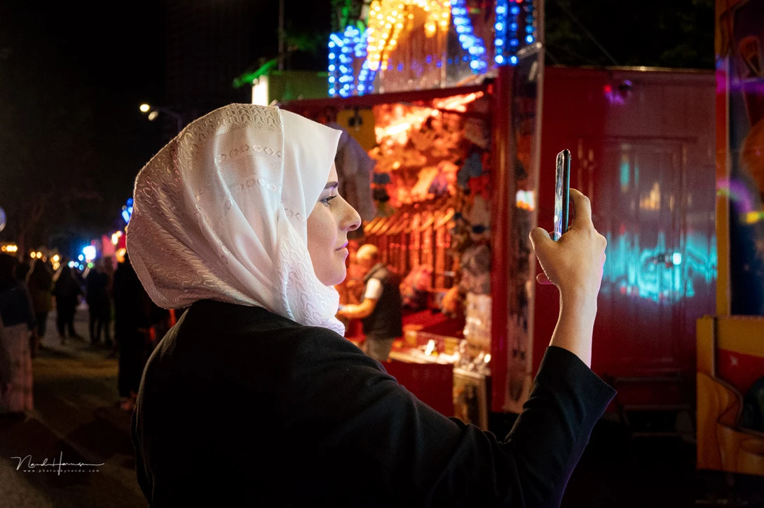 Shooting people at a fairground. Use the available light.