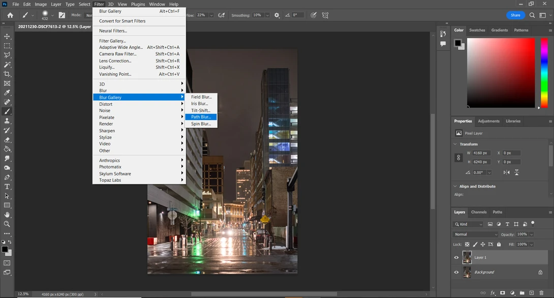 Screenshot of Photoshop with Filter menu open and a wet urban street scene displayed in the main canvas.