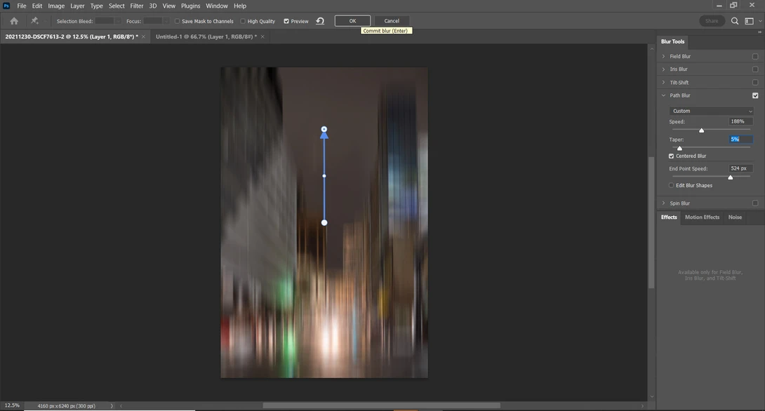 Abstract vertical light streaks with blue, green, and warm tones converging toward center point.