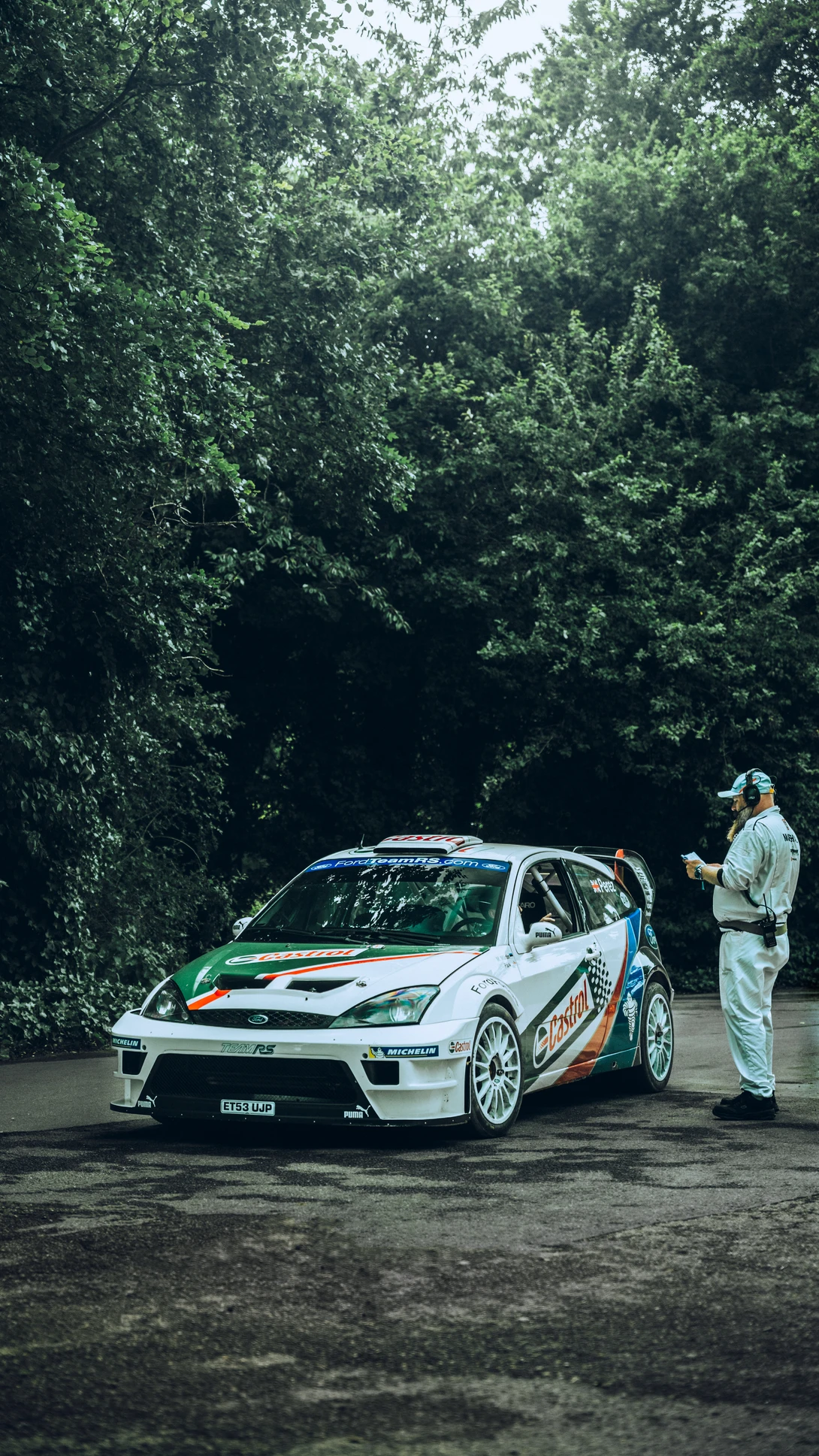 A Ford Focus World Rally Championship car passes by a marshal at the Goodwood festival of speed.
