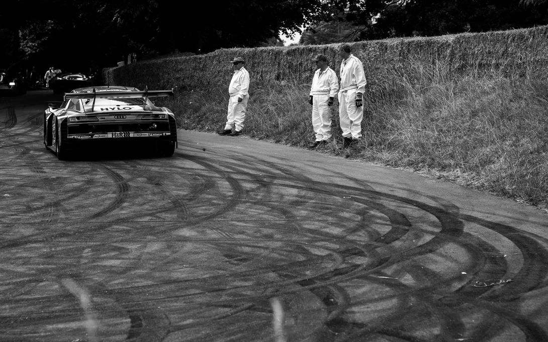 The Nurburgring 24 Hour Winning Audi R8 leaves a trail of tire marks as it passes marshals at the Goodwood festival of speed.