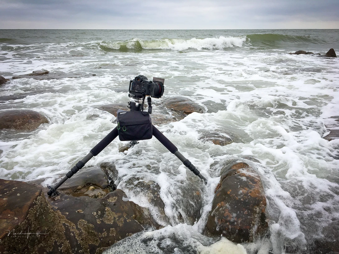 A few thing were happening. Incoming tide made the water rise incredible fast, I couldn't run from this wave, because of the rocks, but the way the tripod was set up kept it in place.