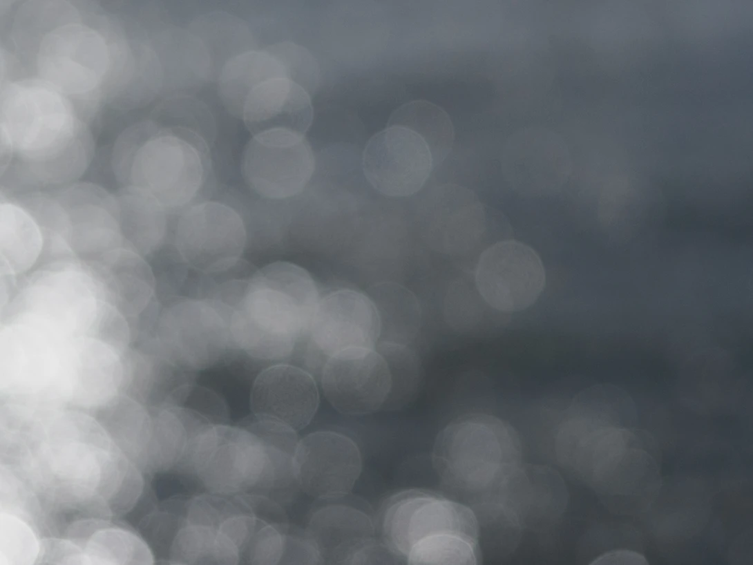 Out-of-focus bokeh circles in monochromatic gray and white tones.