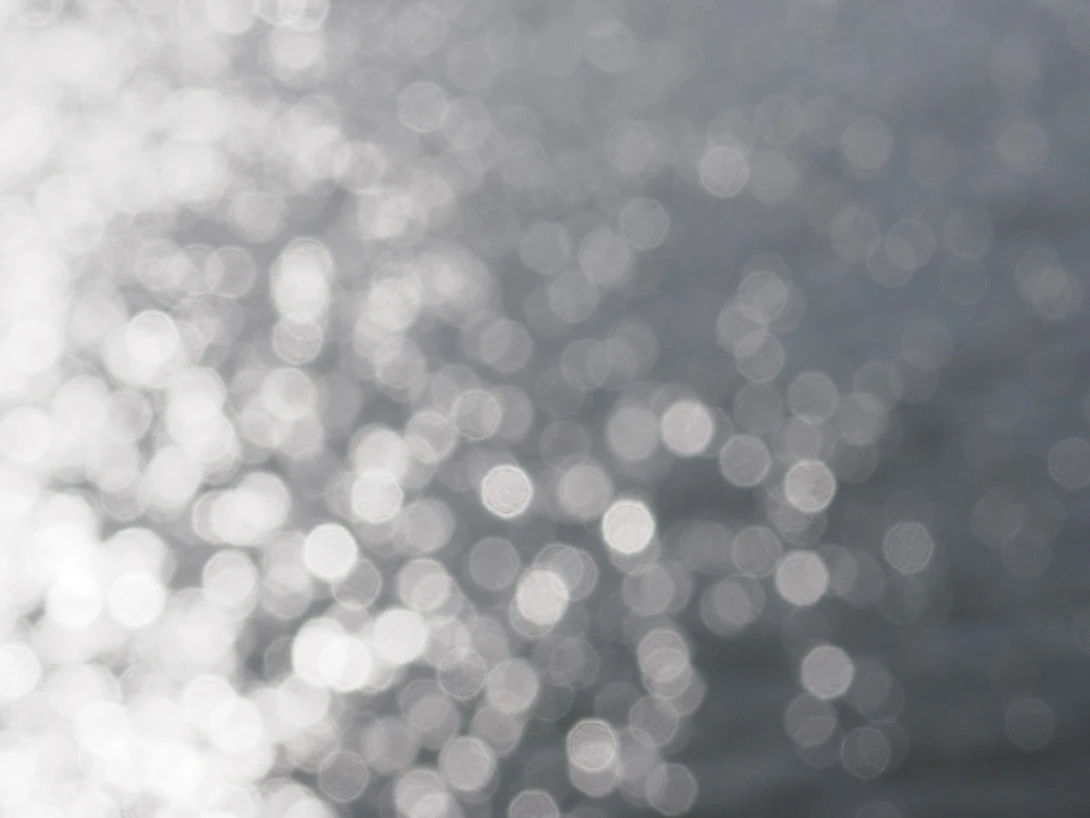 Soft-focus bokeh background with white and gray circular light reflections creating an ethereal atmosphere.