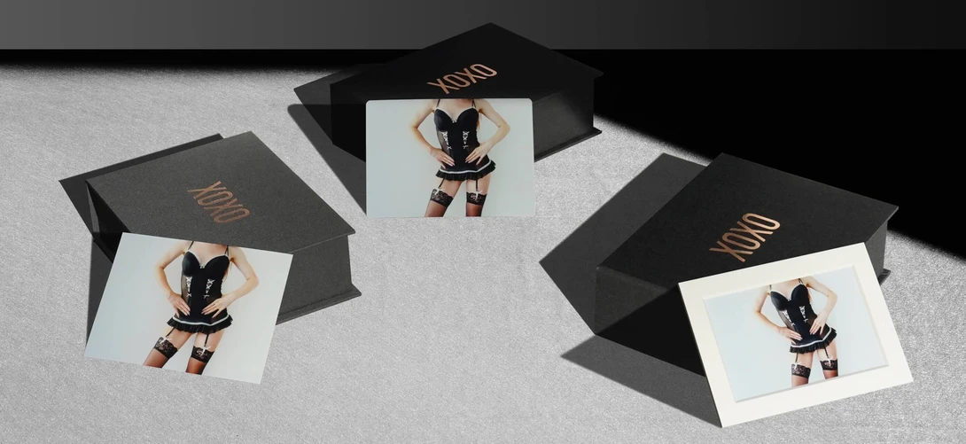 Three black portfolio boxes with gold text arranged on white surface, each opened to reveal a portrait photograph of a person in black and tan outfit.