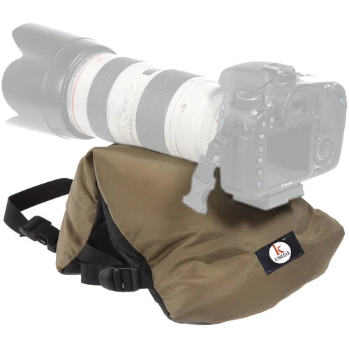 Tan and black camera lens support bag positioned under a telephoto lens mounted on a DSLR camera body.