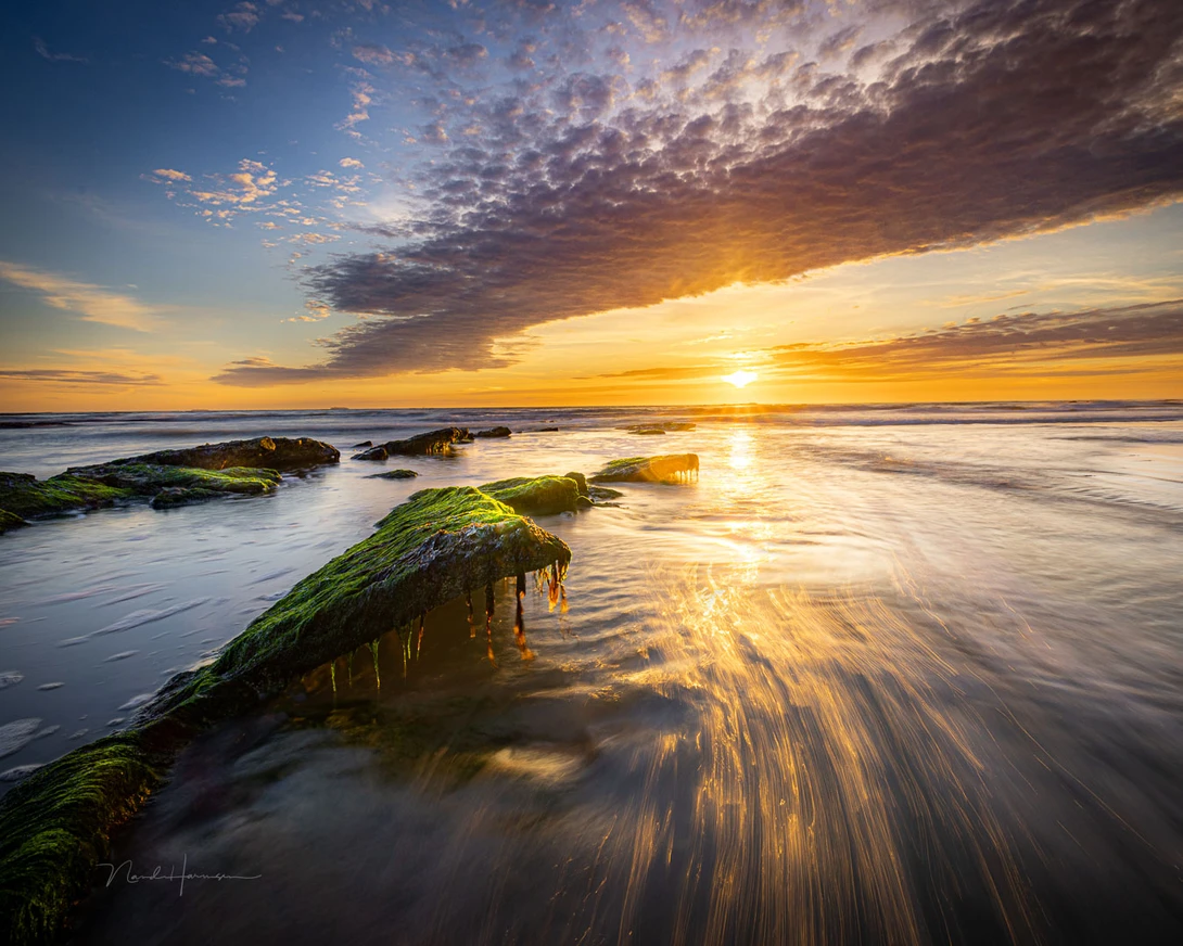 Look a the line of the clouds. It mirrors the line of the rocks in the water. It's not coincidence, but a well thought through composition. If you don't look at the lines in the sky, you will miss the opportunity.