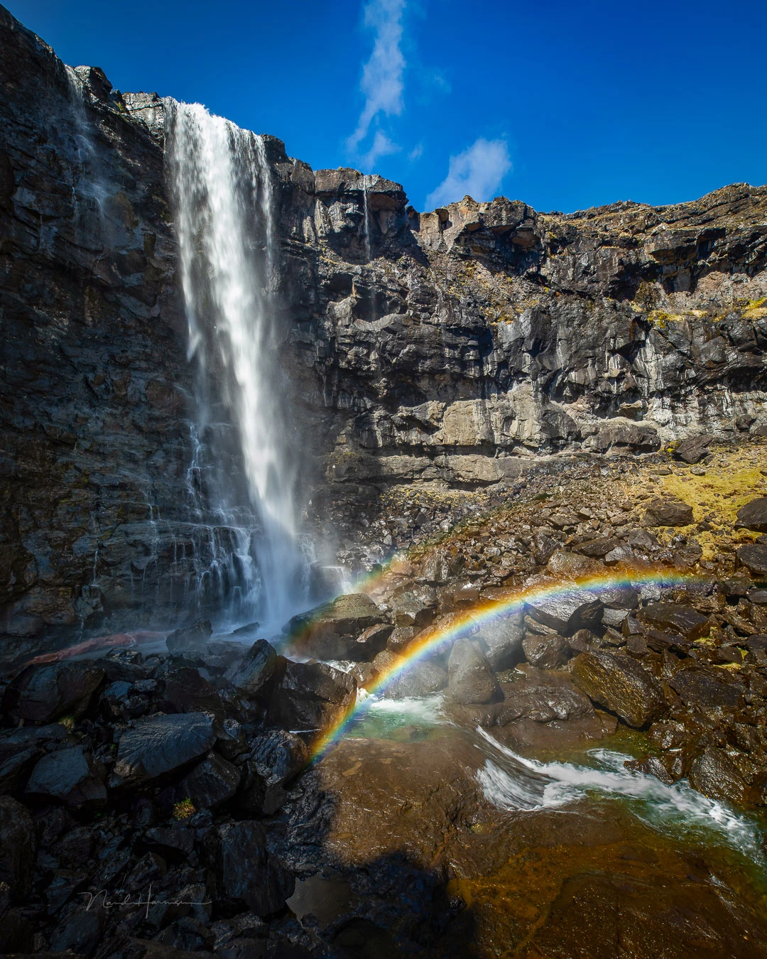 A double rainbow, captured at noon. Try to plan the location of the rainbow by looking at the path of the sun.