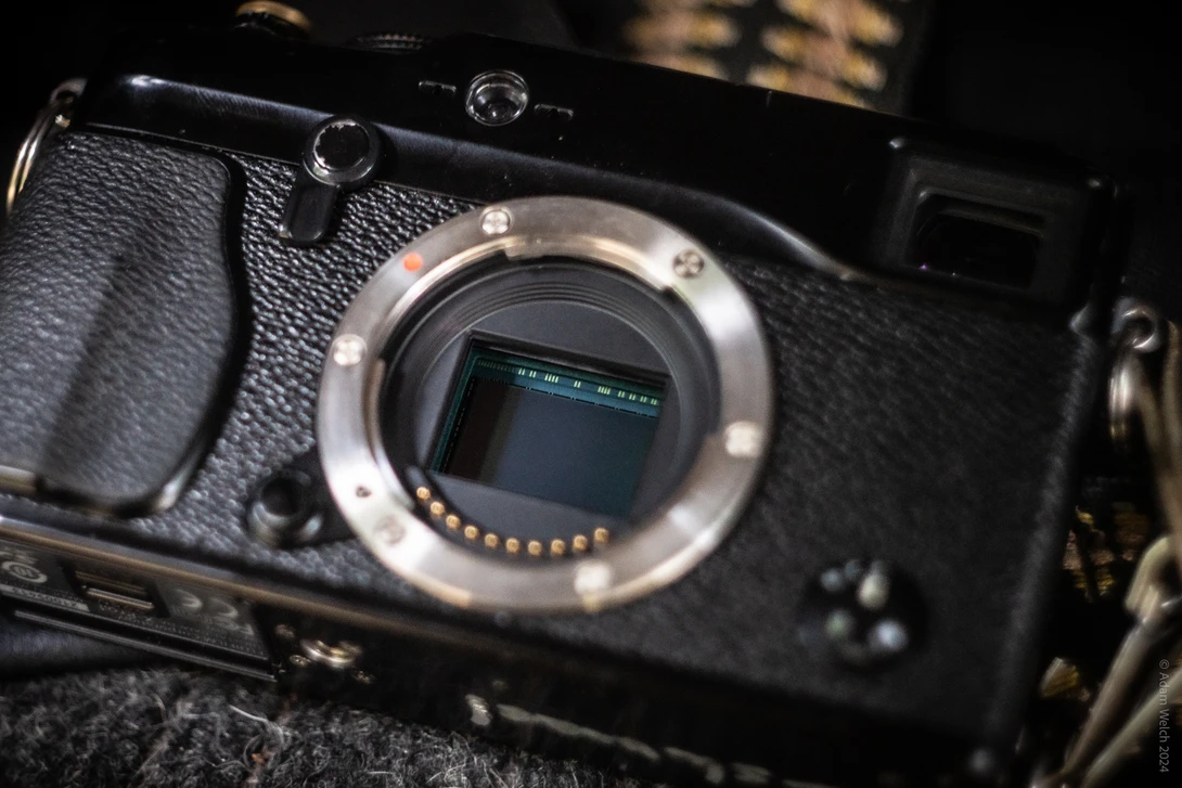 Open camera body showing sensor and mirror cavity with lit ring around the mount.