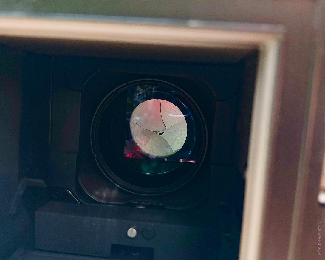 Close-up view through a rifle scope showing a circular reticle pattern with illuminated aiming points.