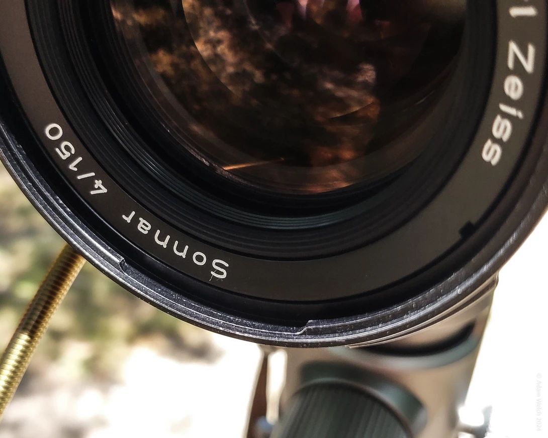 Close-up of a Sonnar 50mm f/1.7 lens showing the glass elements and focusing mechanism.