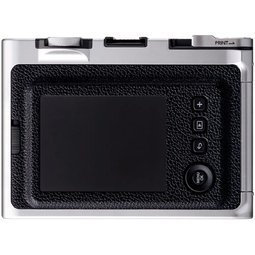 Rear LCD screen of a compact digital camera with black textured rubber grip and silver body.