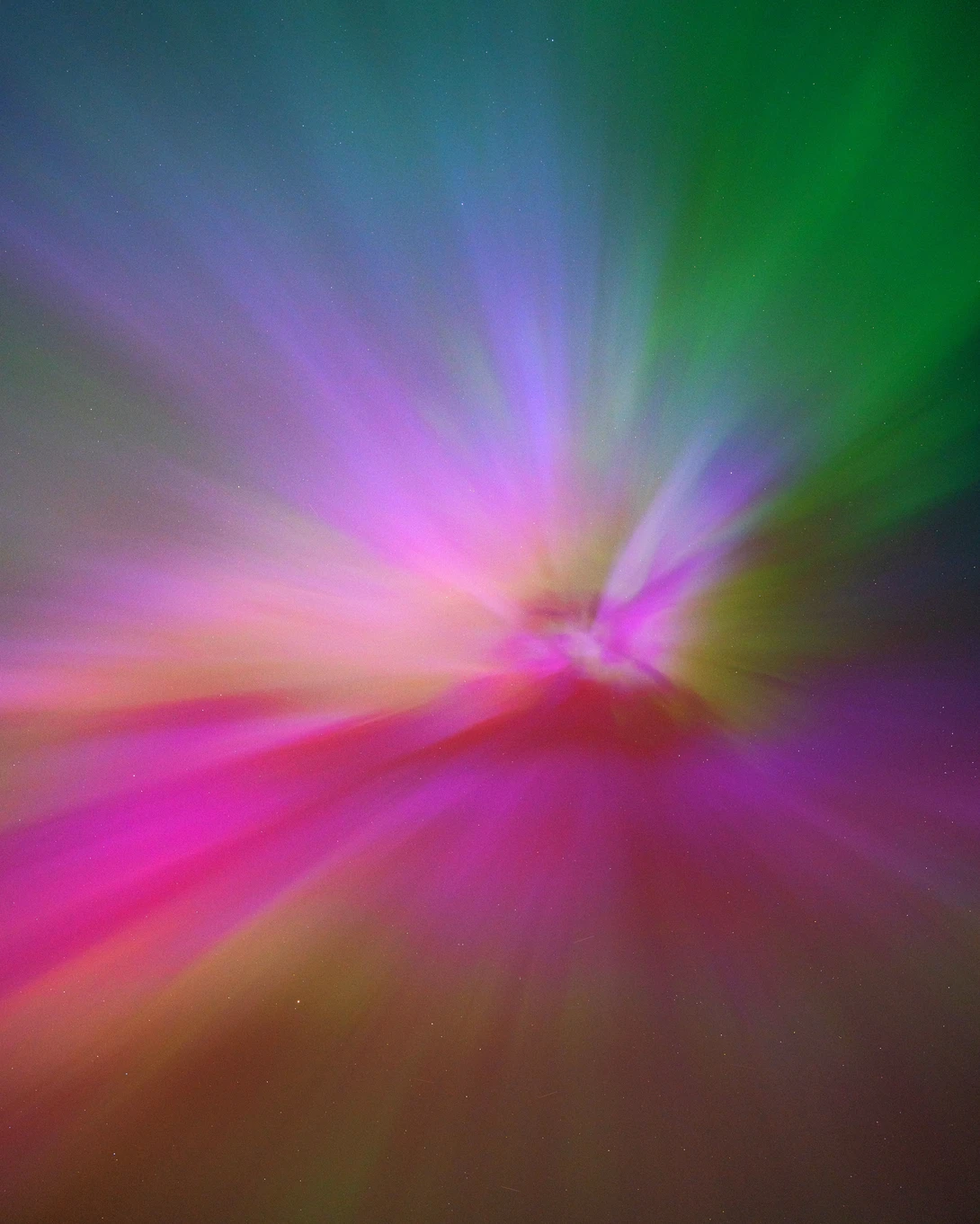 Abstract radial light rays emanating from center in magenta, green, and gold tones.