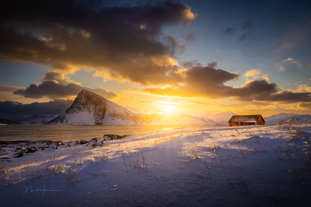 Lines can be found everywhere. You can see it in the clouds and reflected in the snow covered foreground. Everything points towards the subject: the red farmhouse.