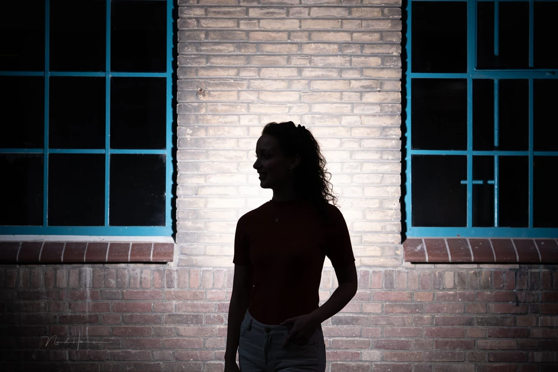 The ambient light is underexposed by three stops. A flash is aimed at the wall to get a silhouette of Sanne. White balance set to daylight, what you normally would do. Colors are correct.