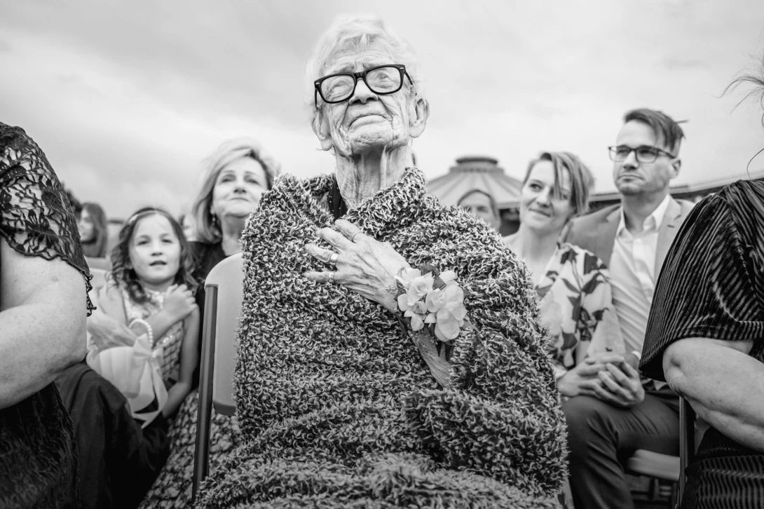 grandmother looks on at wedding as an example of wedding photojournalism