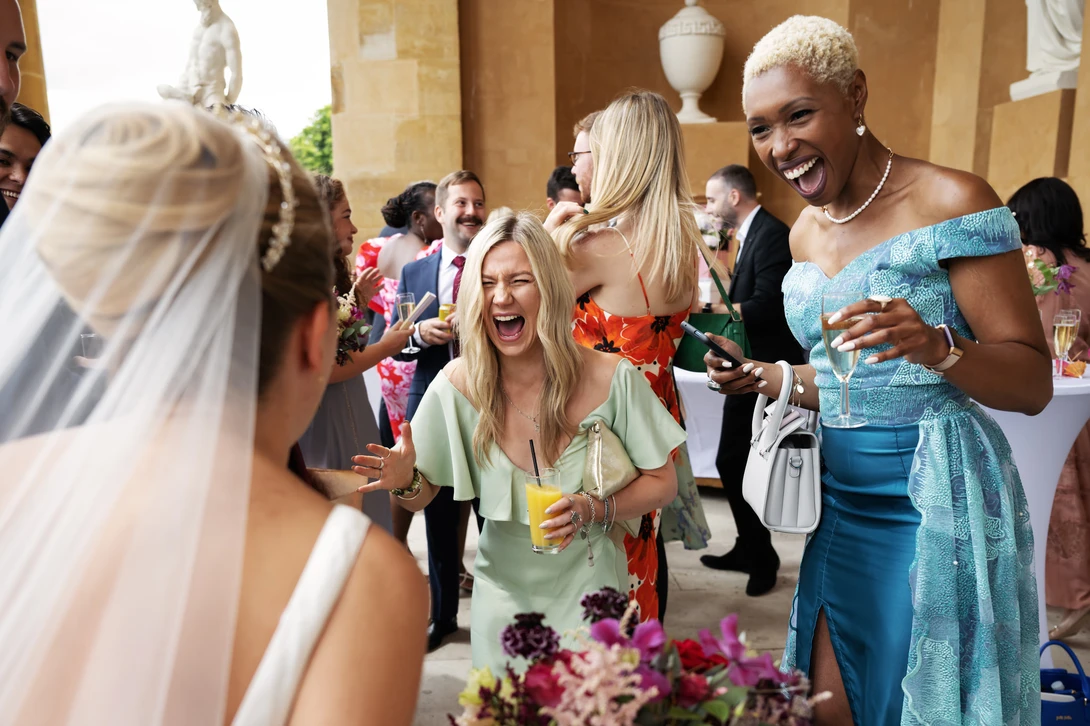 Guests laugh with bride during cocktail hour