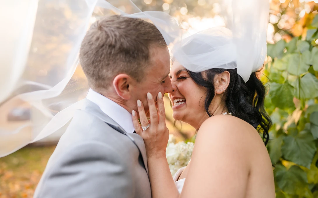 Newlywed couple kisses under veil