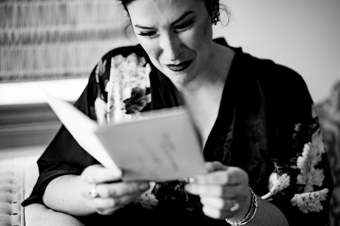 Bride reads letter from groom in wedding photojournalism example