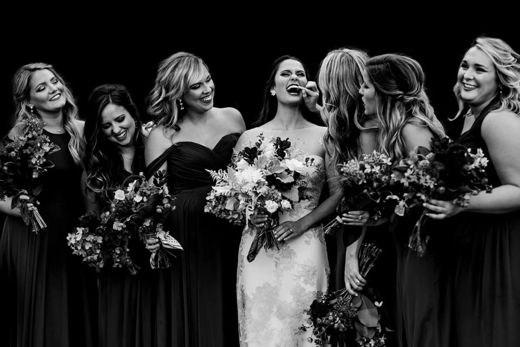 Bridal party laughs in example of wedding photojournalism