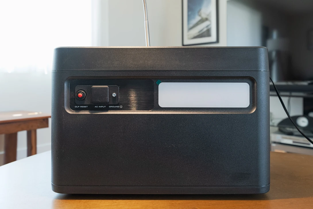 Black portable power station with control panel and display window on wooden table.