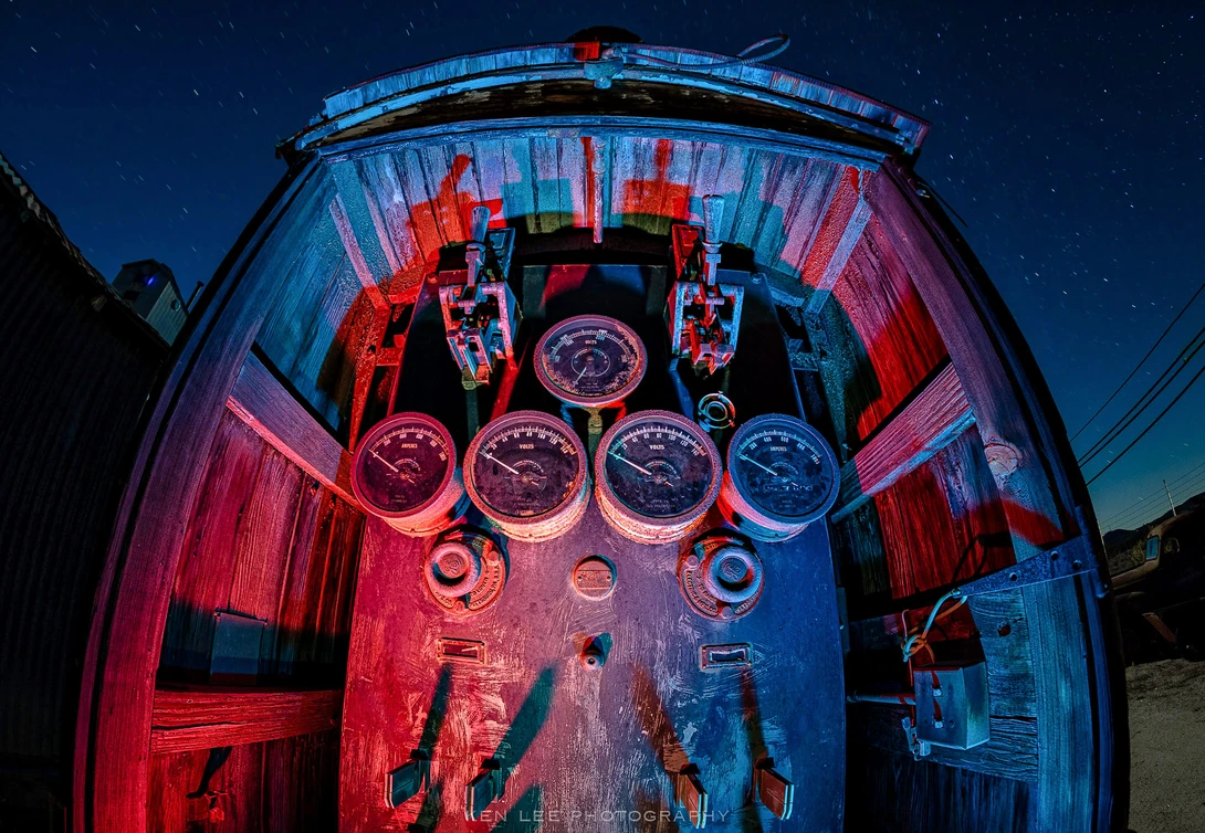 A night photo fisheye view of a Westinghouse AC to DC electric converter inside a wooden enclosure, lit with a handheld light during the exposure.