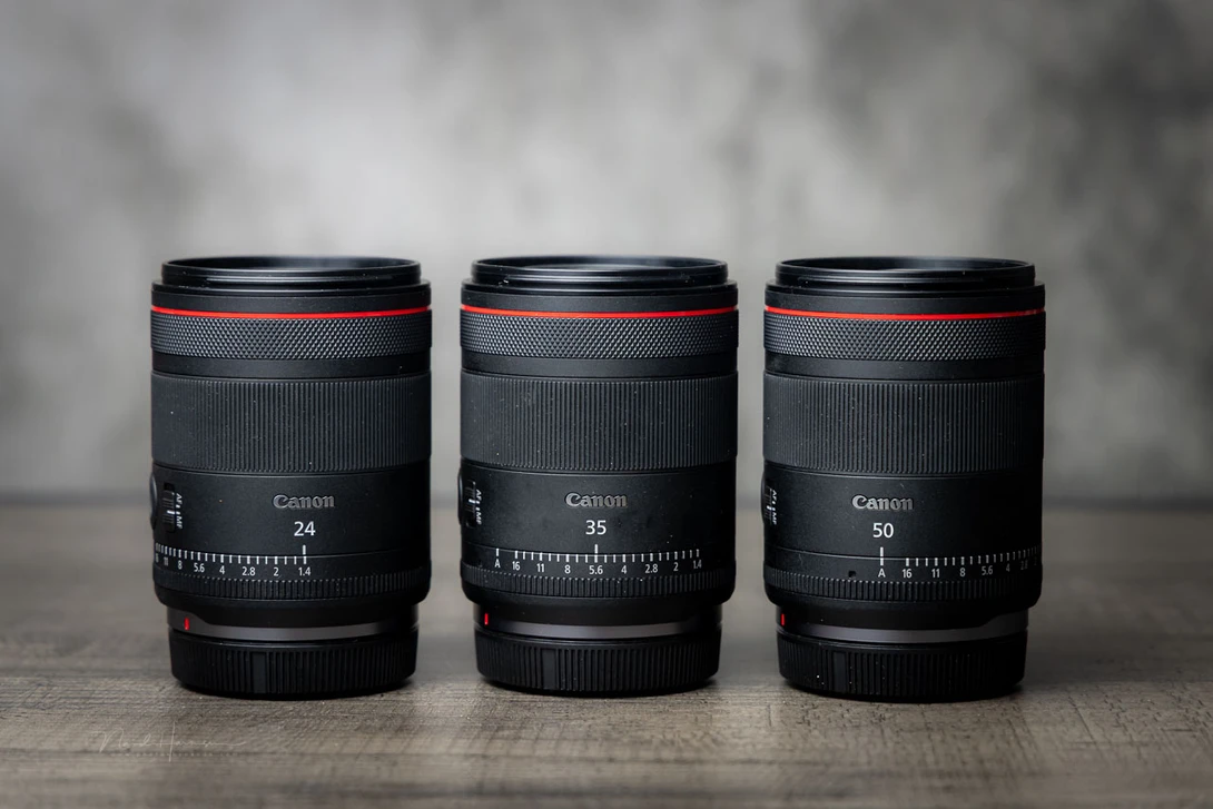 Three Canon RF-mount lenses displayed front-facing: 24mm, 35mm, and 50mm focal lengths.