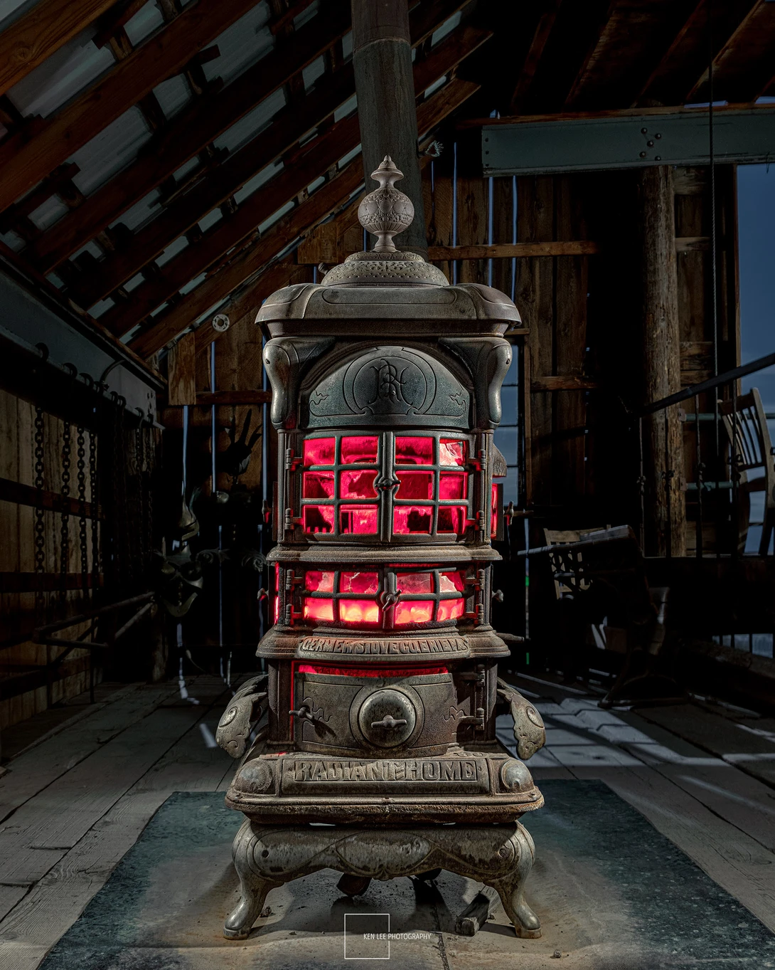 Ornate vintage stove with glowing red interior framed by industrial wooden beams and dark surroundings.